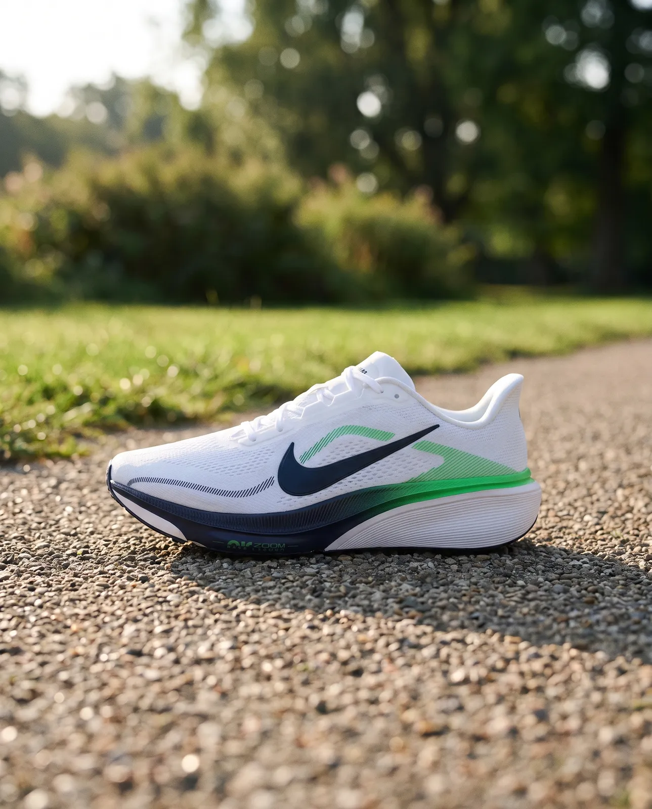 Tênis branco com detalhes azul e verde sobre um caminho de parque